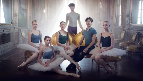Six dancers gathered in a backlit room.