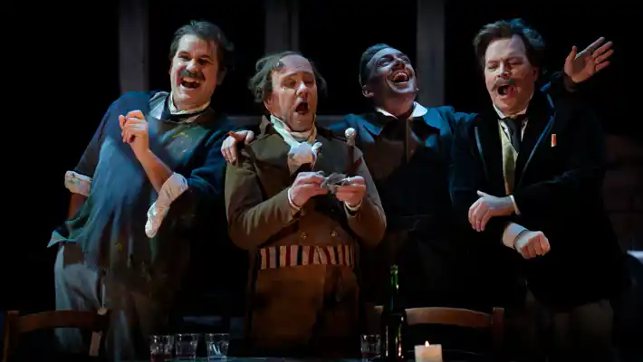 A group of men singing and laughing stand next to each other.