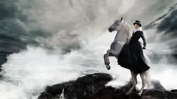 A woman riding a white horse on top of a rocky cliff.