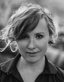 A close-up of a woman with carelessly styled blond hair.