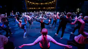 A large group of people dancing on a stage.