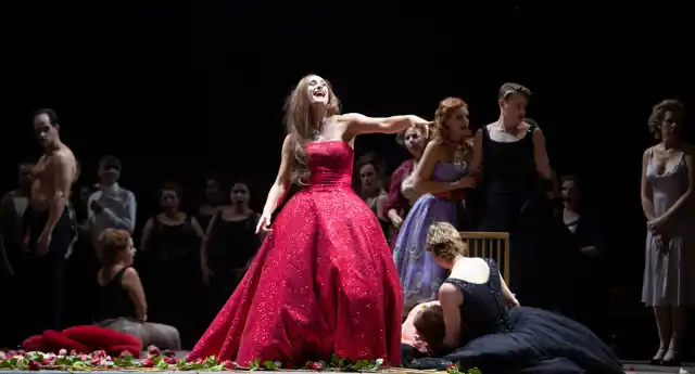 En kvinna i röd klänning på scen.