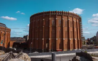En cylindrisk tegelbyggnad som saknar tak mitt i en byggarbetsplats.
