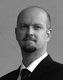 Portrait image of a man wearing a suit and tie.