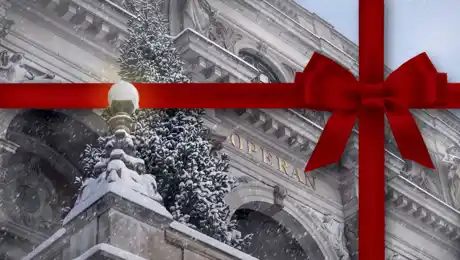 Ett vintrigt operahus med gran på terrassen, inslaget med ett rött snöre.