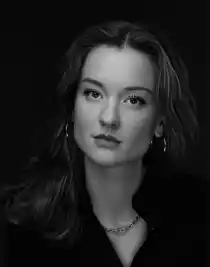 A close-up of a dark-haired woman with large hoop earrings.