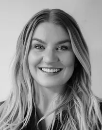 A smiling woman with long blonde hair smiles at the camera.