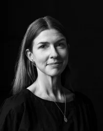 Black and white close-up of a woman with long hair and a long necklace.