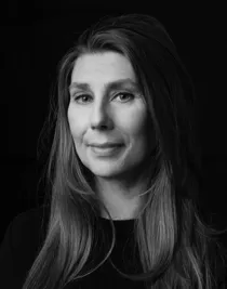 Black and white close-up of a smiling woman with long dark hair.