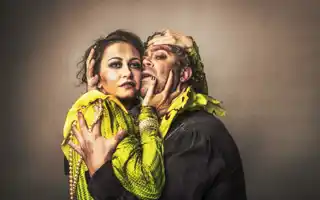 En kvinna och en man är tätt omslingrade, de är smutsiga och kläderna är slitna.