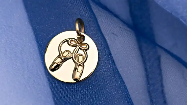 Blue tulle and a gold charm with a pair of pointe shoes.