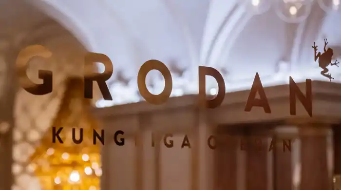 En logotyp klistrad på ett fönster med insyn mot en restaurang.