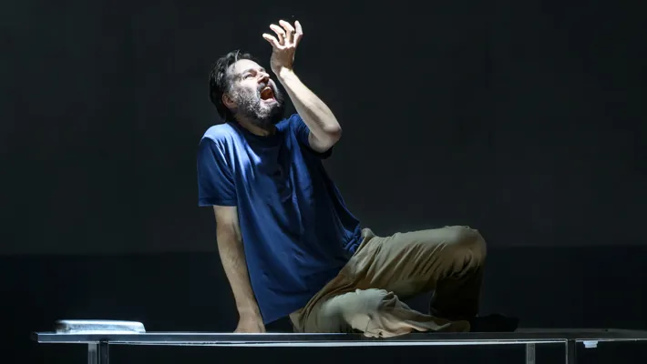 A man sitting on a bench under a light.