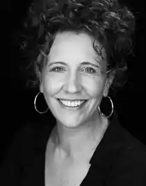 A close-up of a smiling woman with short dark hair.