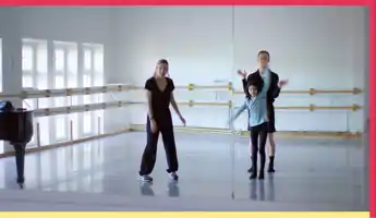 A woman, a young girl and a man try out moves together in a rehearsal room.