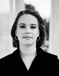 A close-up of a woman in dark clothes, short pageboy hairstyle.