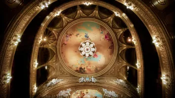 View of a roof and several balconies, a large ceiling painting and a magnificent chandelier in the center.