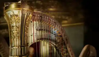 Close-up of the top of a gold-colored harp.