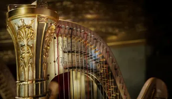 Close-up of the top of a gold-colored harp.