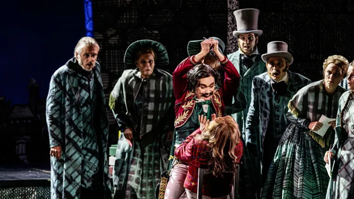 A group of people standing around each other on a stage.