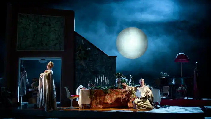 A scene with a man and a woman, behind a large moon.