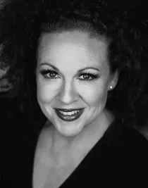 A close-up of a a smiling woman with dark hair.