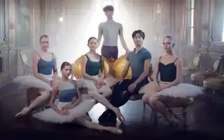 Six dancers gathered in a backlit room.