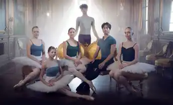 Six dancers gathered in a backlit room.