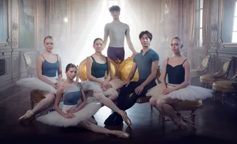 Six dancers gathered in a backlit room.