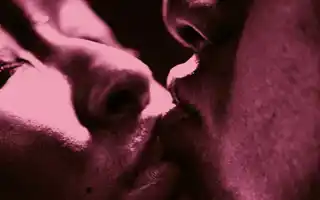 En extrem närbild på ett kyssande par, bara delar av deras ansikten syns.