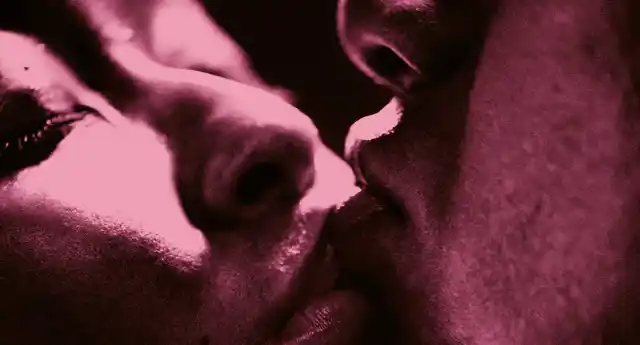 En extrem närbild på ett kyssande par, bara delar av deras ansikten syns.