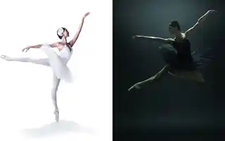A ballerina in a white costume balances on one toe, the other leg is stretched back, opposite her a ballerina dressed in black makes a big jump.