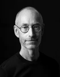 Close-up of a short cut man with a beard and glasses.