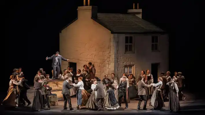 A scene with a large white house and a crowd of people in the foreground dancing.