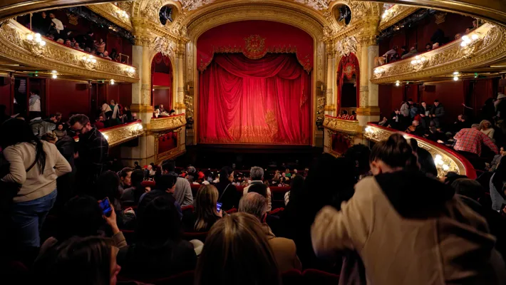 A crowd standing in front of a theater stage.