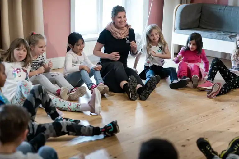 Workshop leader with a group of students in a ring.