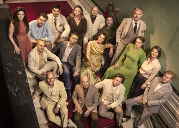 Flera personer står uppställda i en trappa, de tittar upp mot kameran.