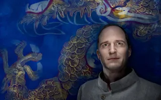 En man står lutad mot en rikt utsmyckad vägg i blått.