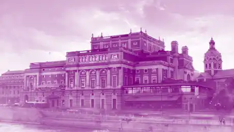 Ett stort hus vid ett vattendrag, en kyrka i bakgrunden, allt täckt av en lila färg.